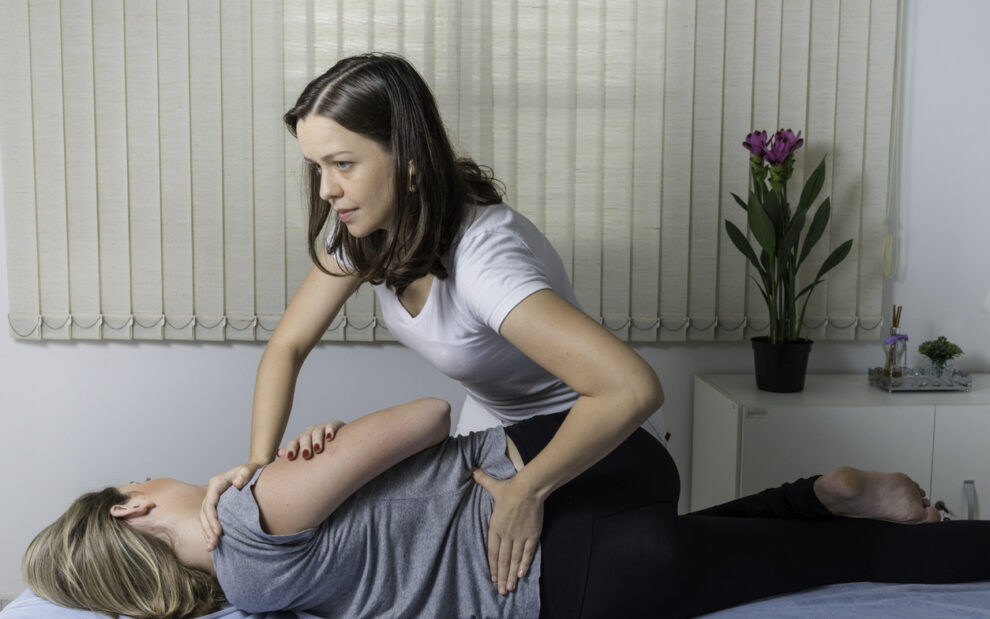 Blond Woman having chiropractic adjustment. Osteopathy, Alternative medicine, pain relief concept. Physiotherapy, sport injury rehabilitation